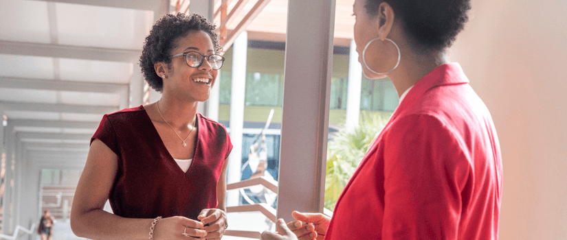 Two african american females, one older one younger, talk to each other. 