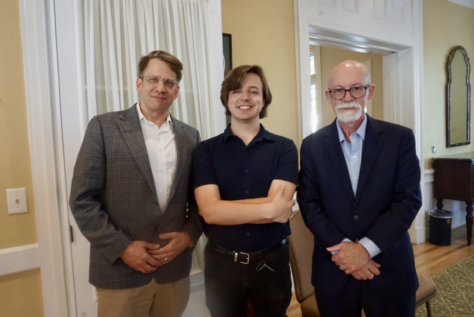 three men standing and smiling