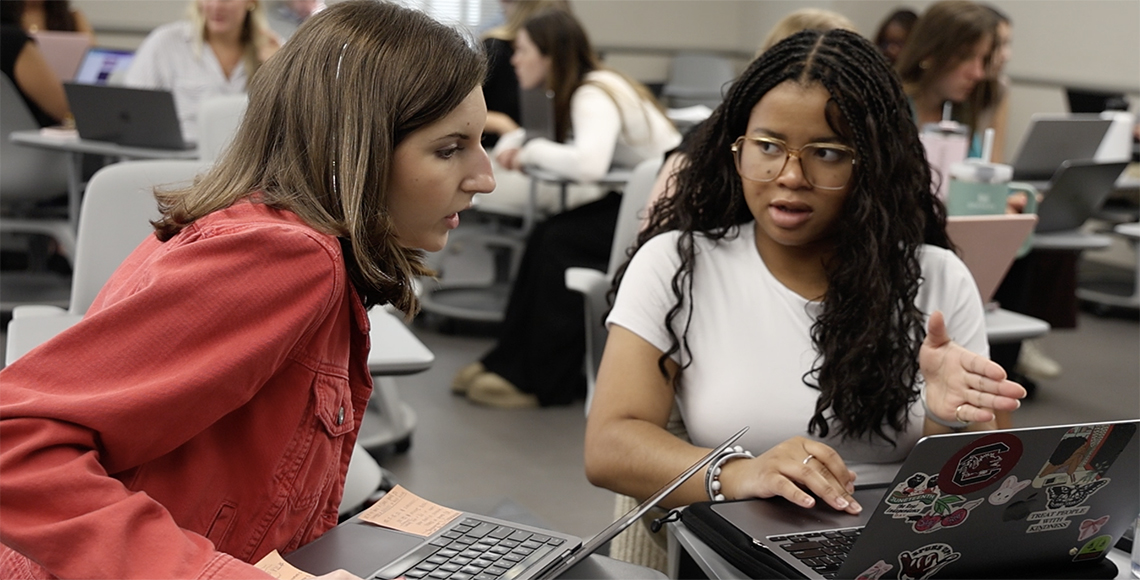 two girls working at a computer