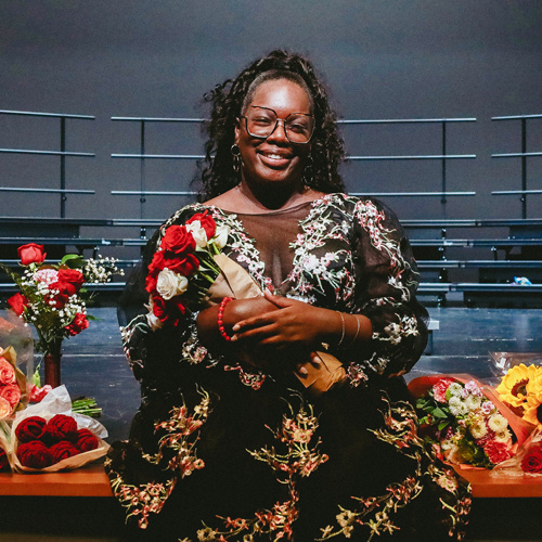 Woman smiles while holding flowers