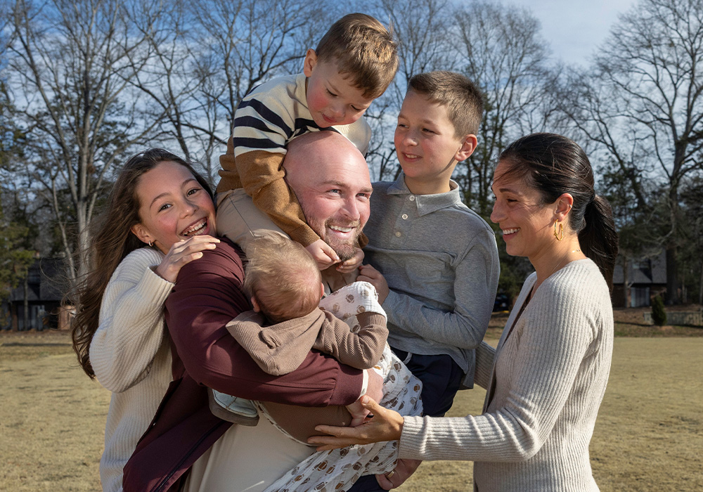 Connor Shaw, his wife and their four kids are all smiles, posing together at a rec field