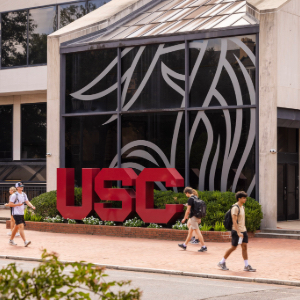 Students walking past the USC letters outside of Russell House.